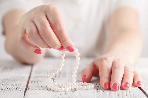 Woman hand with pearl necklace