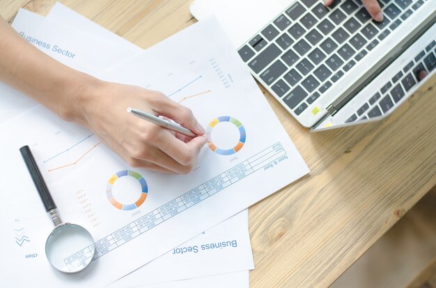 woman hand with pen and business report