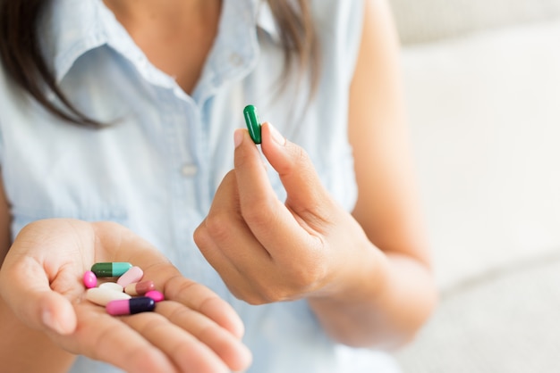 Woman hand with pills medicine tablets and capsule in her hands.