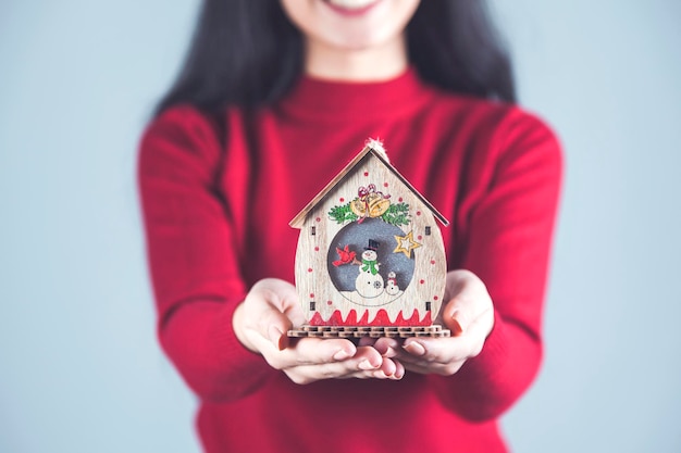 Photo woman hand wooden house model