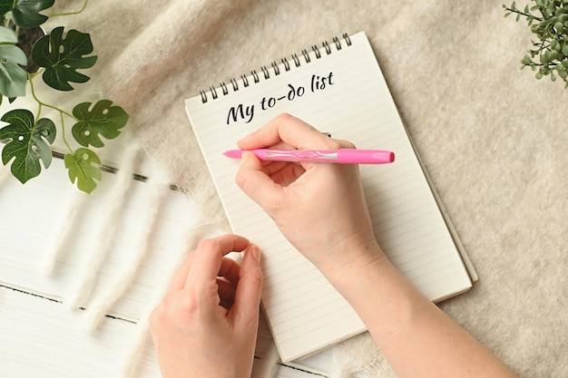 Woman hand writing my todo list on note paper Making New Years resolutions Planning things