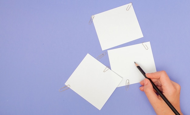 Женщина почерков на бумаге для заметок на фиолетовом