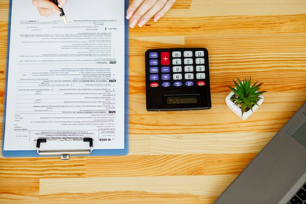 Woman hand writing or signing in a document