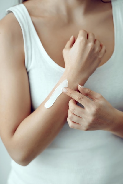 Woman hands applying moisturizing cream to her skin Soft skin skincare concept Hand skin care