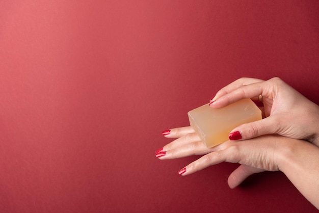 Woman hands applying soap on fingers on plain copy space