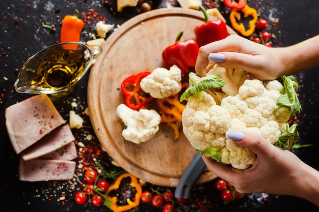 Photo woman hands breaking cauliflower. vegetarian organic food. preparing of healthy salad concept