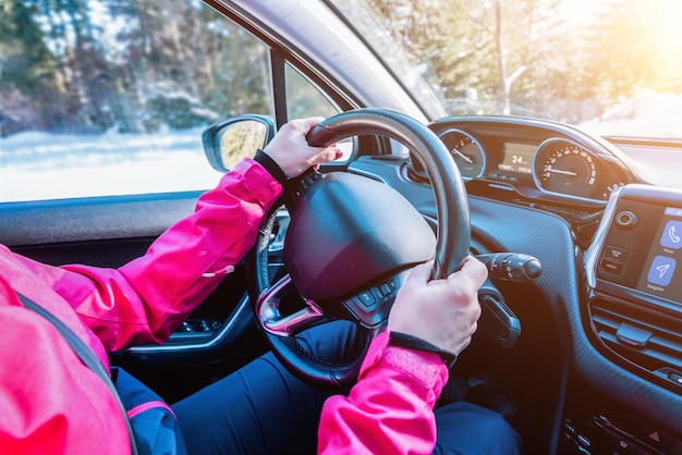 Женские руки на руле автомобиля Современный интерьер автомобиля с умной приборной панелью Концепция зимнего путешествия