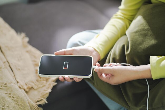 Photo woman hands charging mobile phone battery with low battery plugging a charger in a smart phone with energy bank powerbank power charger modern lifestyle energy technology concept