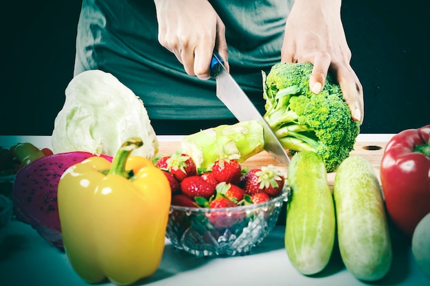 Woman hands chopping a broccoli to makes salad