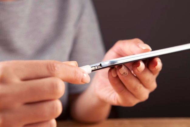 Woman hands connect charger to smartphone