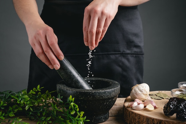 Woman hands cooking pouring salt into mortar