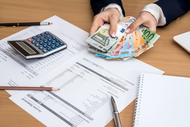 Woman hands counting euro money  with document home budget lapptop pen and calculator