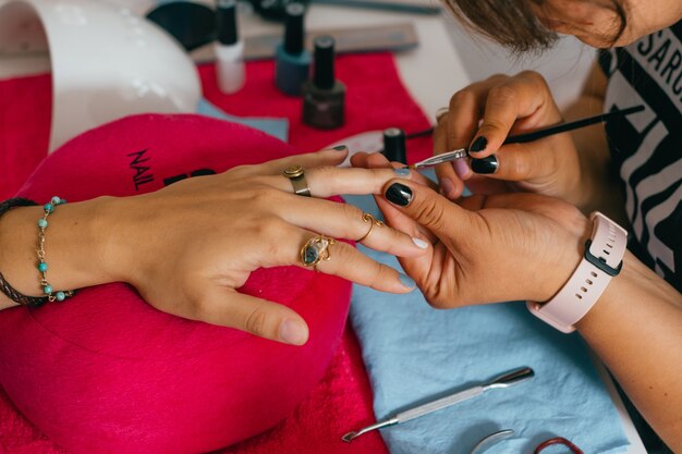 Photo woman hands doing manicure in salon.