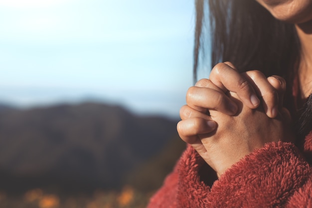 Женщина руки сложить в молитве в прекрасном фоне природы с солнечным светом в старинном цветовом тоне