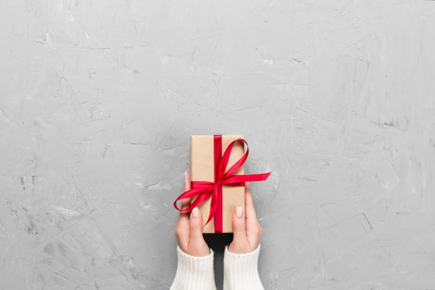 Woman hands give wrapped Present box