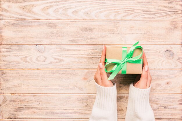 Woman hands give wrapped present
