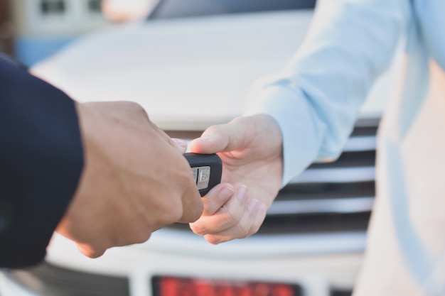 Foto la donna passa a dare l'automobile chiave al nuovo proprietario