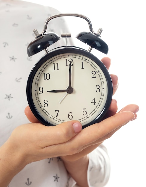 Woman hands holding black alarm clock