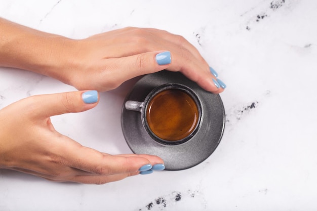 Woman hands holding coffee cup of expresso blue nails high quality photo