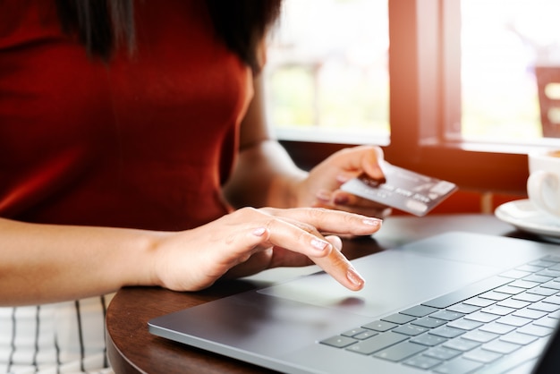 Woman hands holding credit card and using laptop. Online shopping