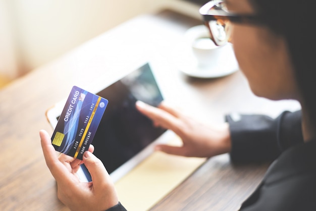 女性両手クレジットカードを使用してタブレットを使用してオンラインショッピング技術お金財布オンライン支払い