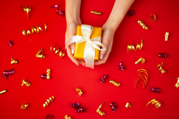 Woman hands holding gift box top view