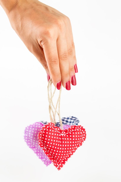 Woman hands holding heart figure made from red