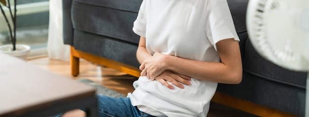 Foto le mani della donna che tengono lo stomaco e i crampi del periodo di dolore perché hanno le mestruazioni