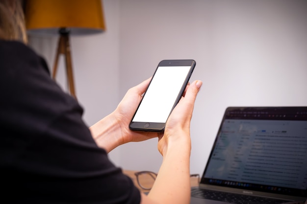 Женщина руки держит смартфон использования дома с ноутбуком на столе онлайн-шоппинг