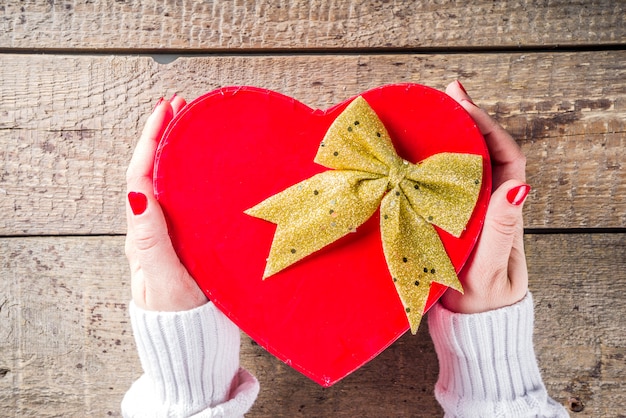 Foto la donna passa la tenuta del contenitore di regalo di san valentino