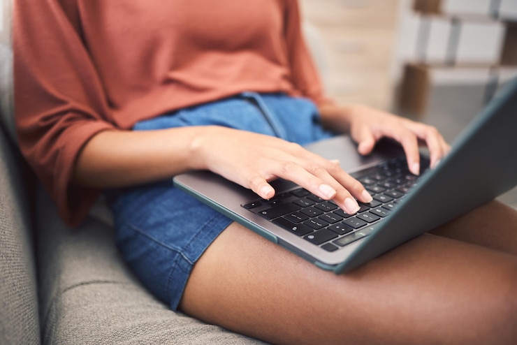 Photo woman hands and home laptop for remote work working employee and copywriting editor on sofa female person email client and reading review of project in living room freelancer and networking