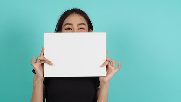 Woman hands is holding empty board on black background.Blank white A4 paper.