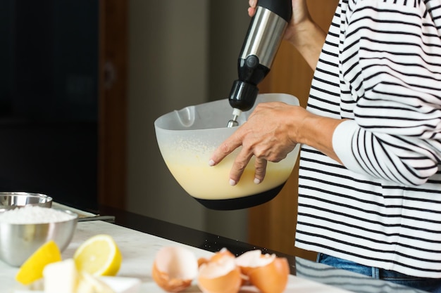 Foto mani della donna che impastano la pasta durante la cottura della torta di mele