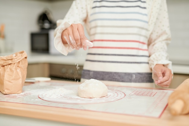 Foto mani di donna che impastano pasta fresca per fare il pane