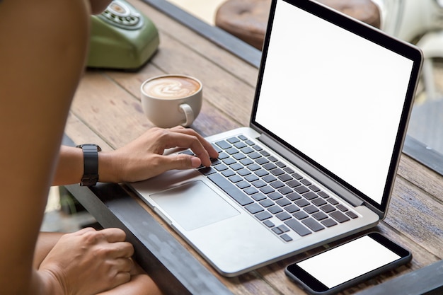 woman hands on laptop with mobile phone and coffee