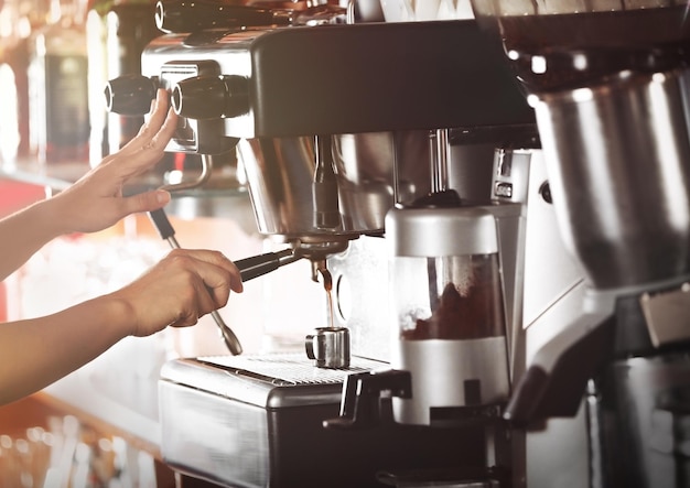 Foto mani della donna che fanno caffè espresso in caffè