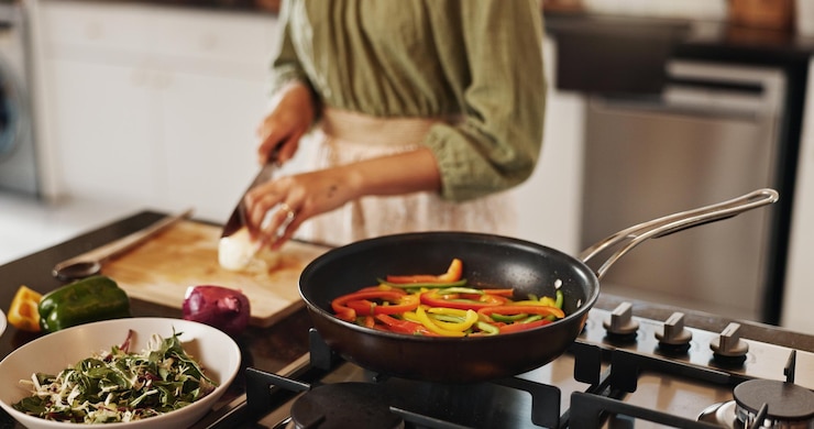 Photo woman hands and meal prep with pan for stir fry food or vegetables in kitchen at home closeup female person and cutting with organic ingredients for nutrition diet or healthy recipe on stove