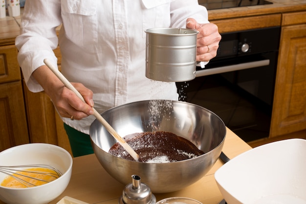 Woman hands melted chocolate mixture with flour