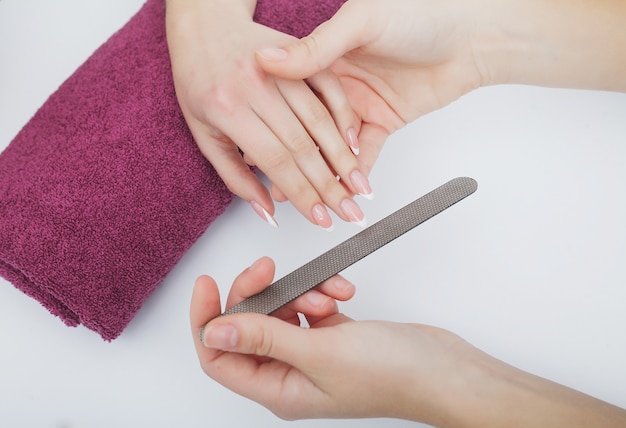 Woman hands in a nail salon receiving a manicure procedure. SPA manicure.