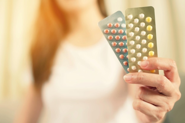 Woman hands opening birth control pills in hand eating Contraceptive pill Contraception reduces childbirth and pregnancy concept Leave space to write descriptive text