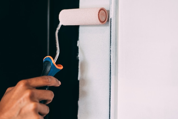 Woman hands painting with a roller