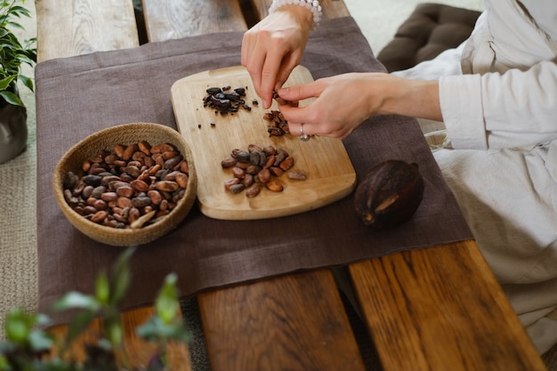 Woman hands peeling raw organic cacao beans for ceremony