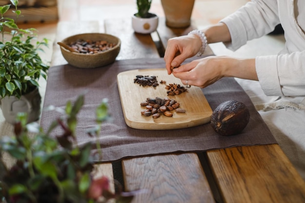 Женщина руки пилинг сырых органических какао-бобов для церемонии