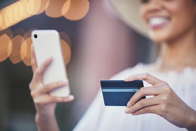 Woman hands and phone with credit card for online shopping ecommerce or purchase in the city Hand of happy female shopper holding smartphone for internet banking app 5G connection or transaction