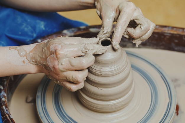 Woman hands on pottery wheel. Craftsman artist shapes pot