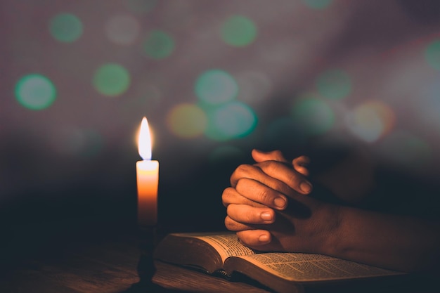 Foto mani di donna che pregano sulla sacra bibbia