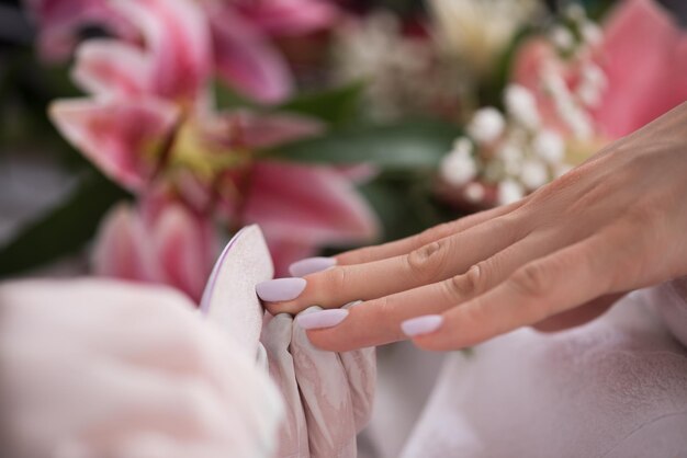 Mani di donna che ricevono una manicure nel salone di bellezza. limatura delle unghie. primo piano, messa a fuoco selettiva.