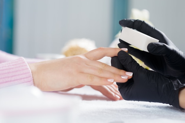 Woman hands receiving a manicure in beauty salon