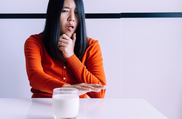 Woman hands refusing a glass of milk,Female having allergy milk,Lactose intolerance concept