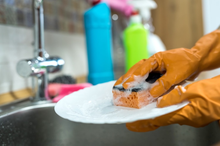 Photo woman hands rinsing plate under running water in the sink. housework